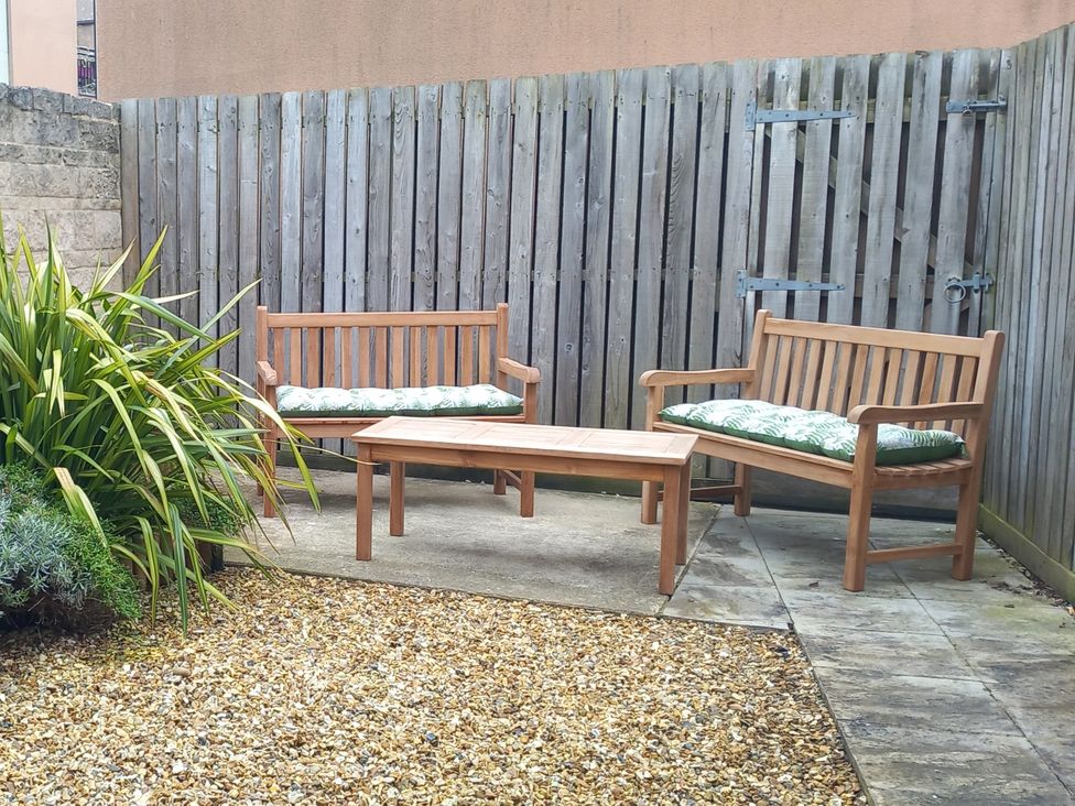 A garden with wooden benches and a coffee table at Olympic Cottage in Portland