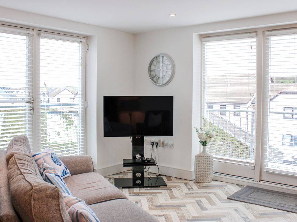 A living room with a television and a sofa at Estuary View in Kingsbridge