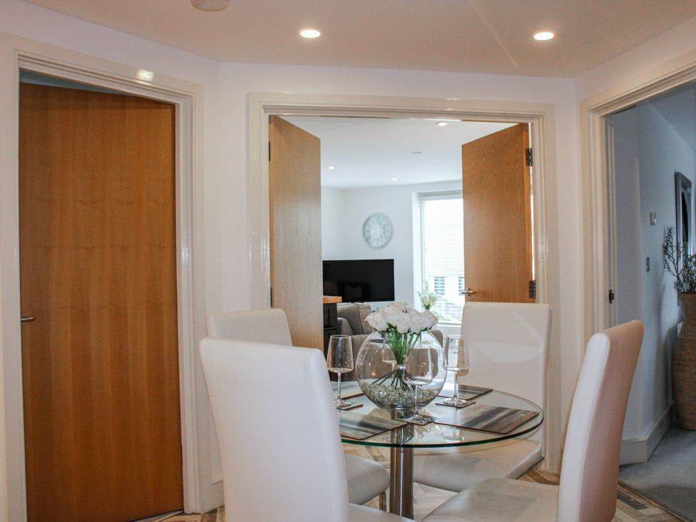 A dining area with a glass table and chairs at Estuary View in Kingsbridge