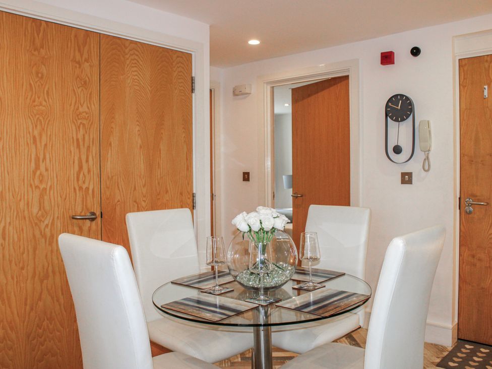 A dining room with a glass table and chairs at Estuary View in Kingsbridge