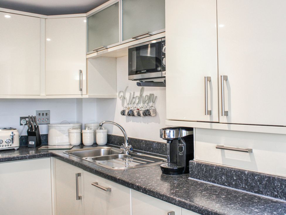 A kitchen with a sink and microwave at Estuary View in Kingsbridge