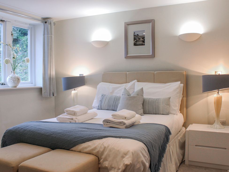A bedroom with a bed and bedside tables at Estuary View in Kingsbridge
