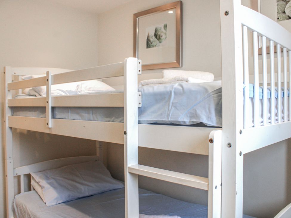 A bunk bed with white bedding at Estuary View in Kingsbridge