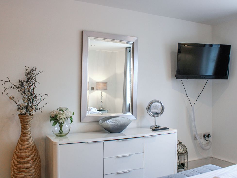 A bedroom with a television and dresser at Estuary View in Kingsbridge
