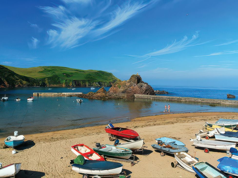 A beach with boats on the sand and people walking at Estuary View in Kingsbridge