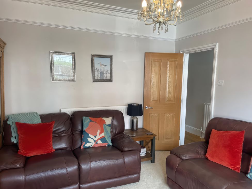 A living room with a sofa and armchair at Pedaller's Cottage in Weymouth