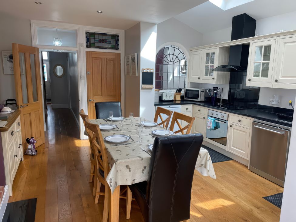 A kitchen featuring a dining table and appliances at Pedaller's Cottage in Weymouth