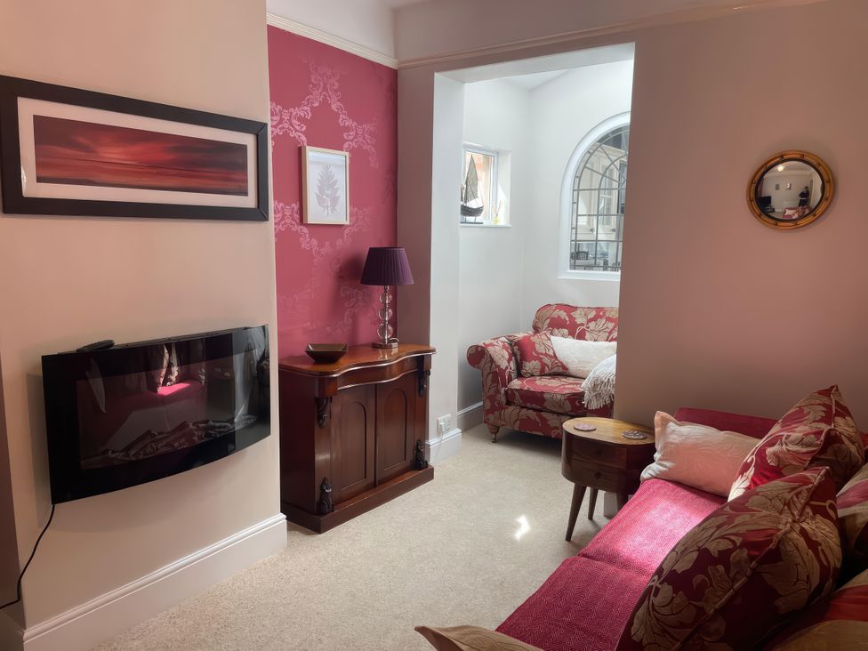 A living room with a sofa and a lamp at Pedaller's Cottage in Weymouth