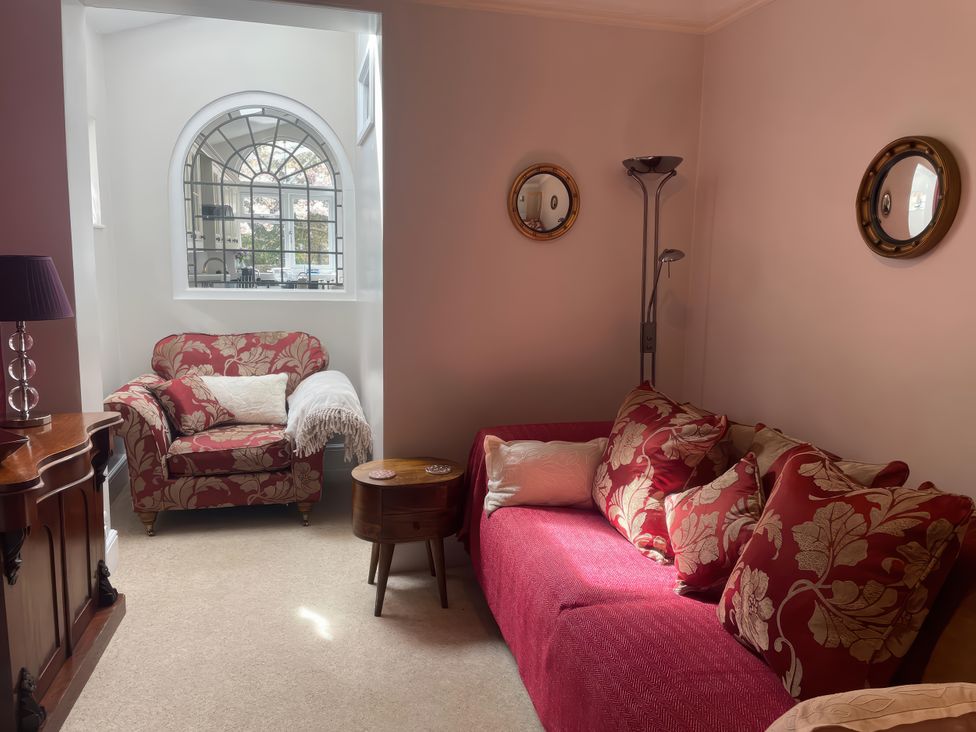 A living room with a sofa and an armchair at Pedaller's Cottage in Weymouth