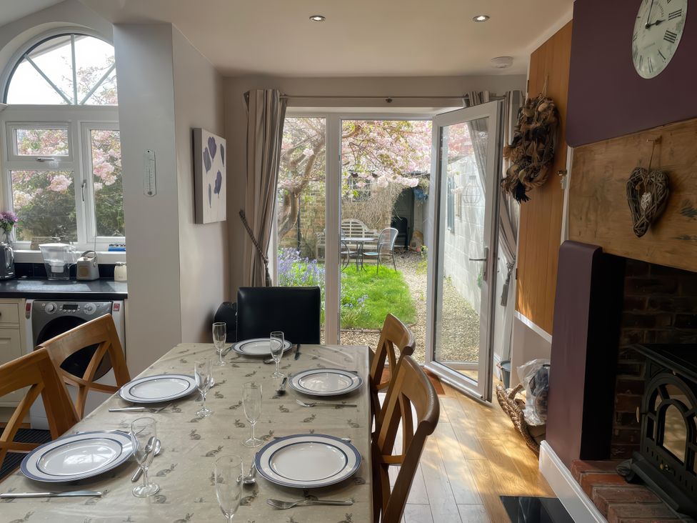 A dining room with a table set for a meal at Pedaller's Cottage in Weymouth
