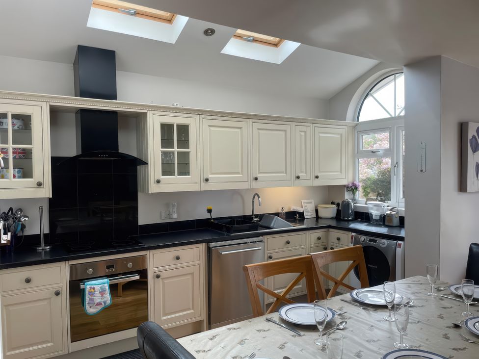 A kitchen with cabinets and appliances at Pedaller's Cottage in Weymouth