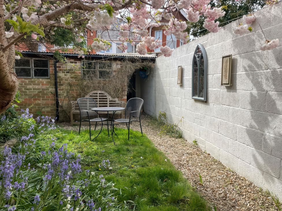 A garden with a table and chairs at Pedaller's Cottage in Weymouth