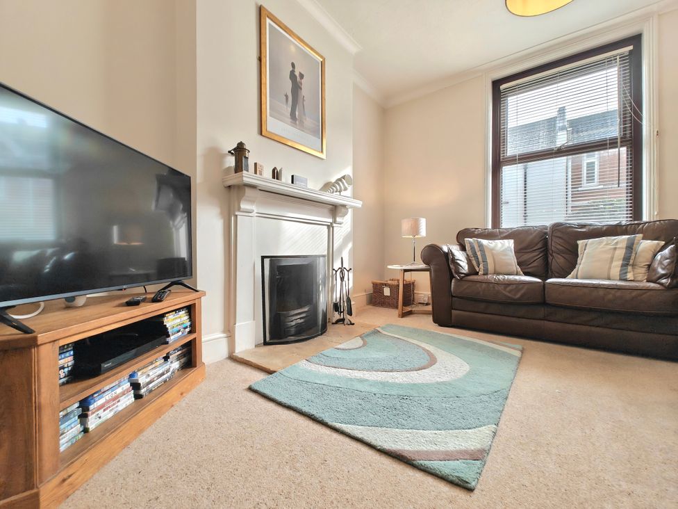 A living room with a television and a sofa at Quay Cottage in Weymouth