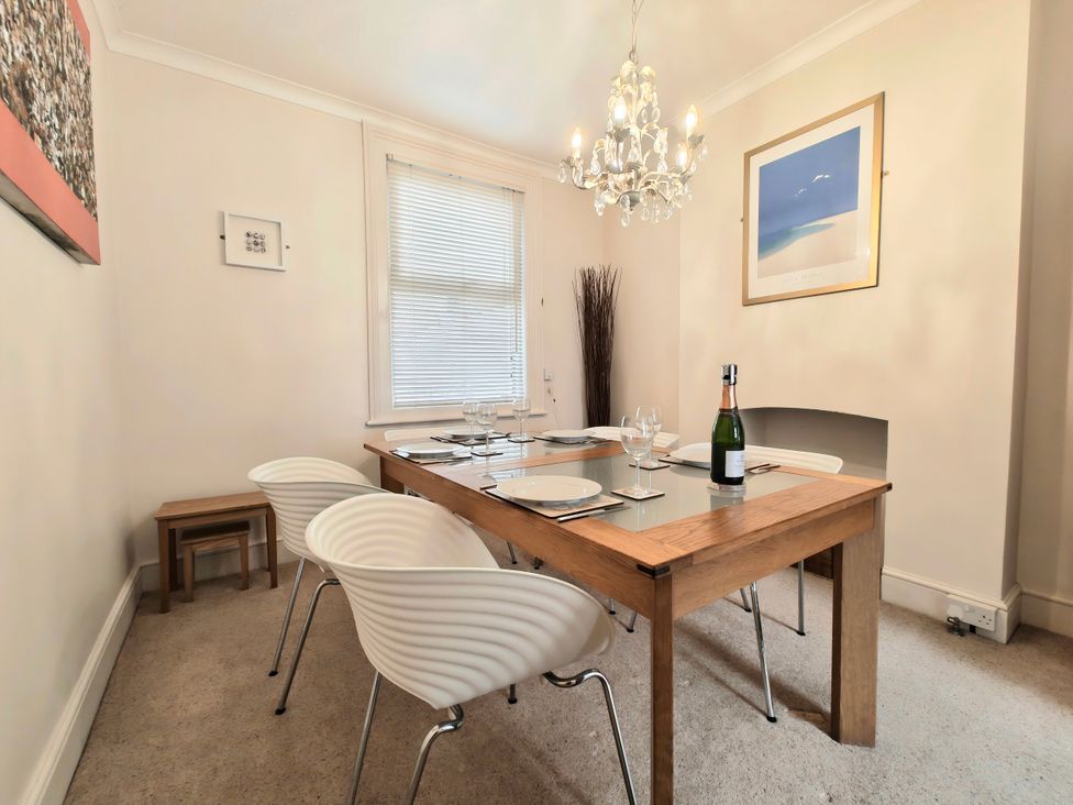 A dining room with a table and chairs at Quay Cottage in Weymouth