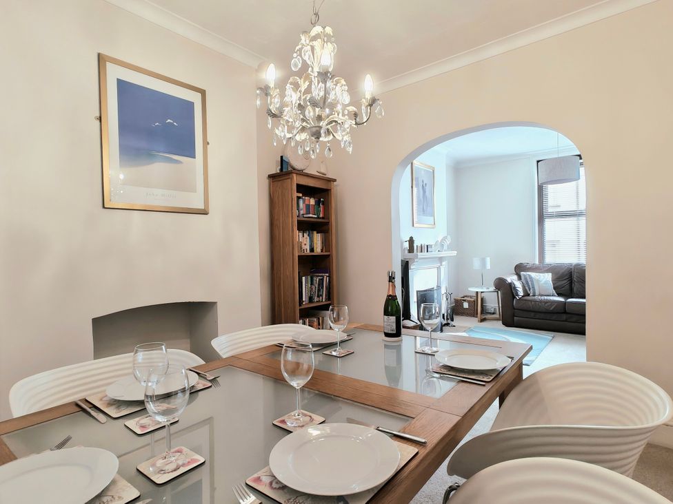A dining room with a table set for dinner at Quay Cottage in Weymouth