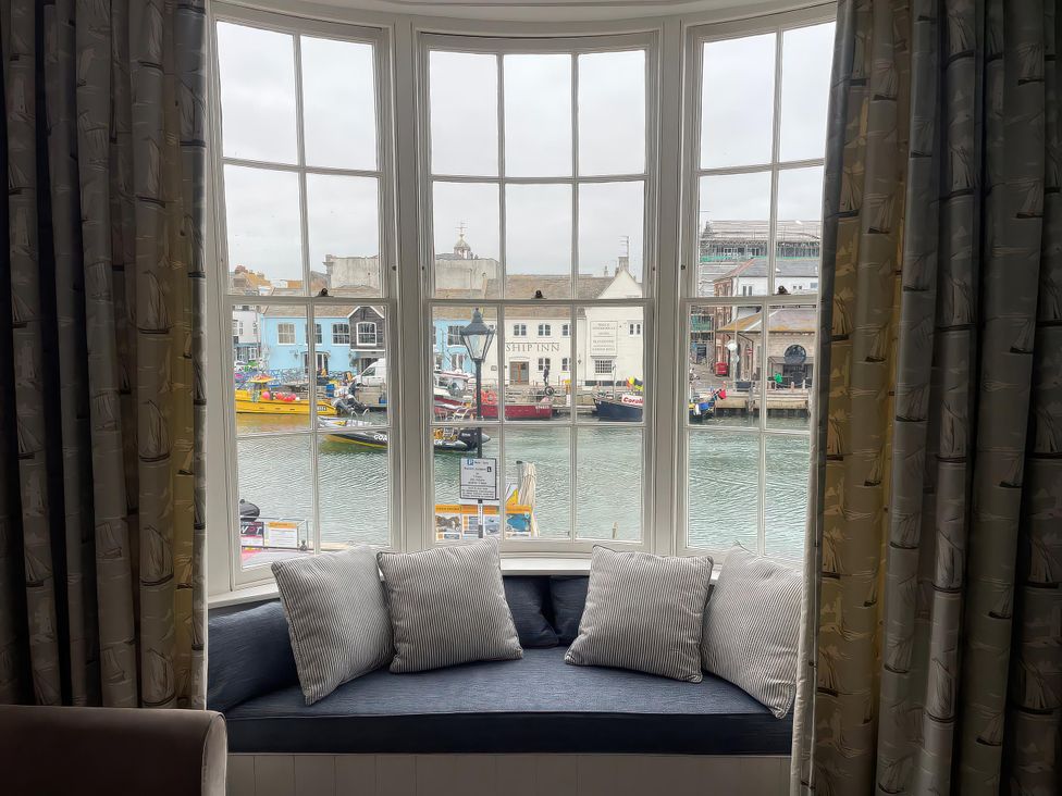 A window with cushions overlooking the harbor at Safe Harbour Brewers Quay harbour