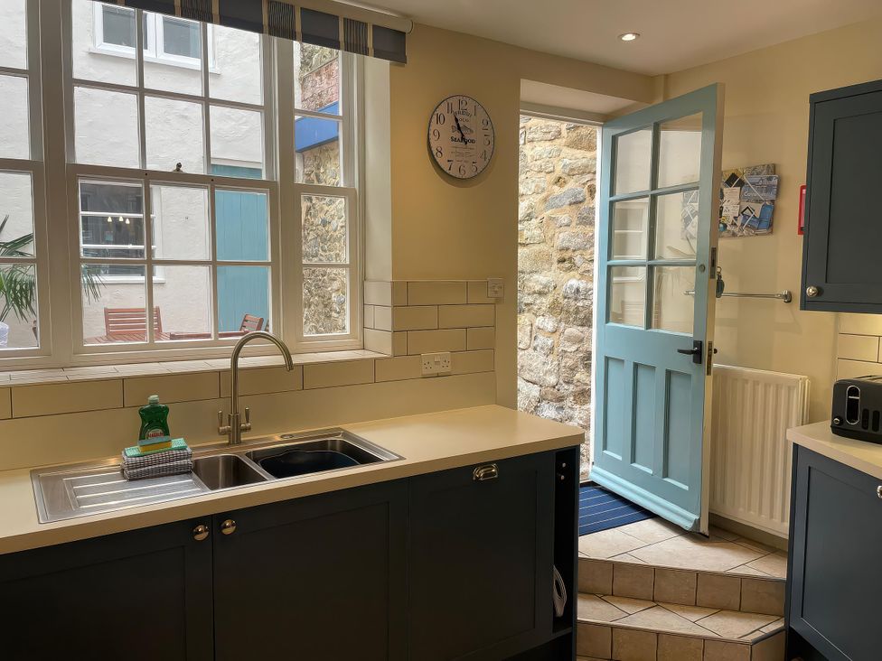 A kitchen with a sink and door to the outside at Safe Harbour in Brewers Quay harbour