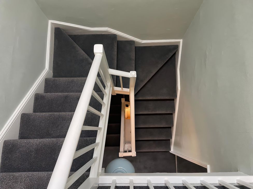 A staircase with a handrail and light fixture at Safe Harbour in Brewers Quay harbour