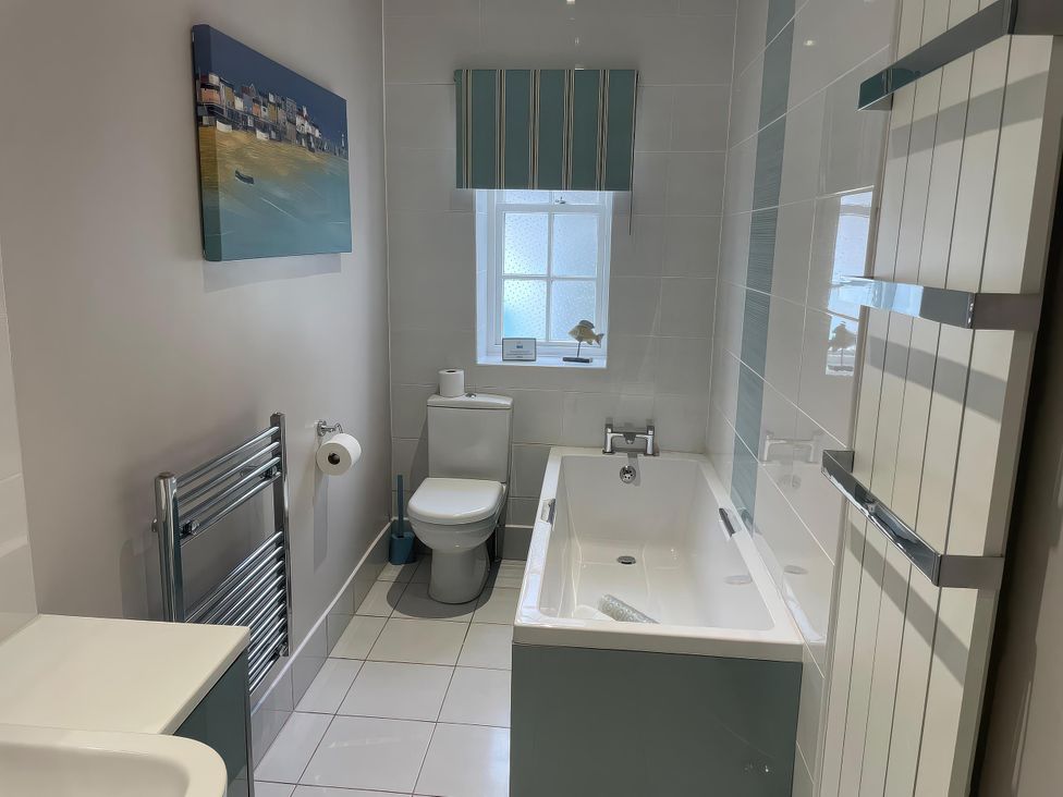 A bathroom with a bathtub, toilet, and sink at Safe Harbour in Brewers Quay harbour