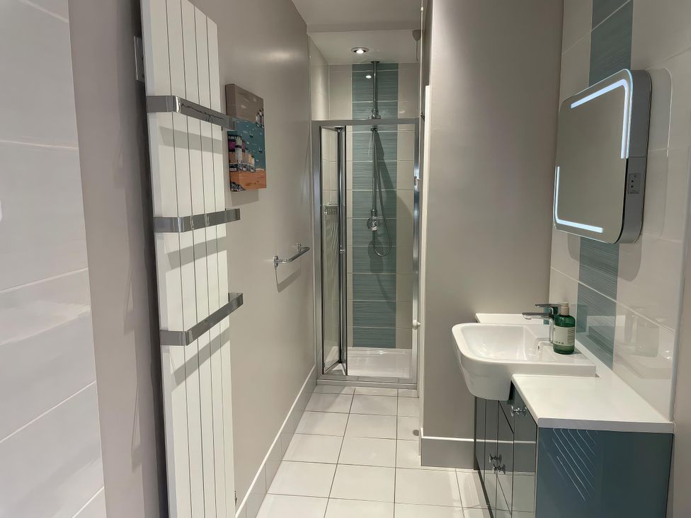 A bathroom with a shower and wash basin at Safe Harbour Brewers Quay harbour