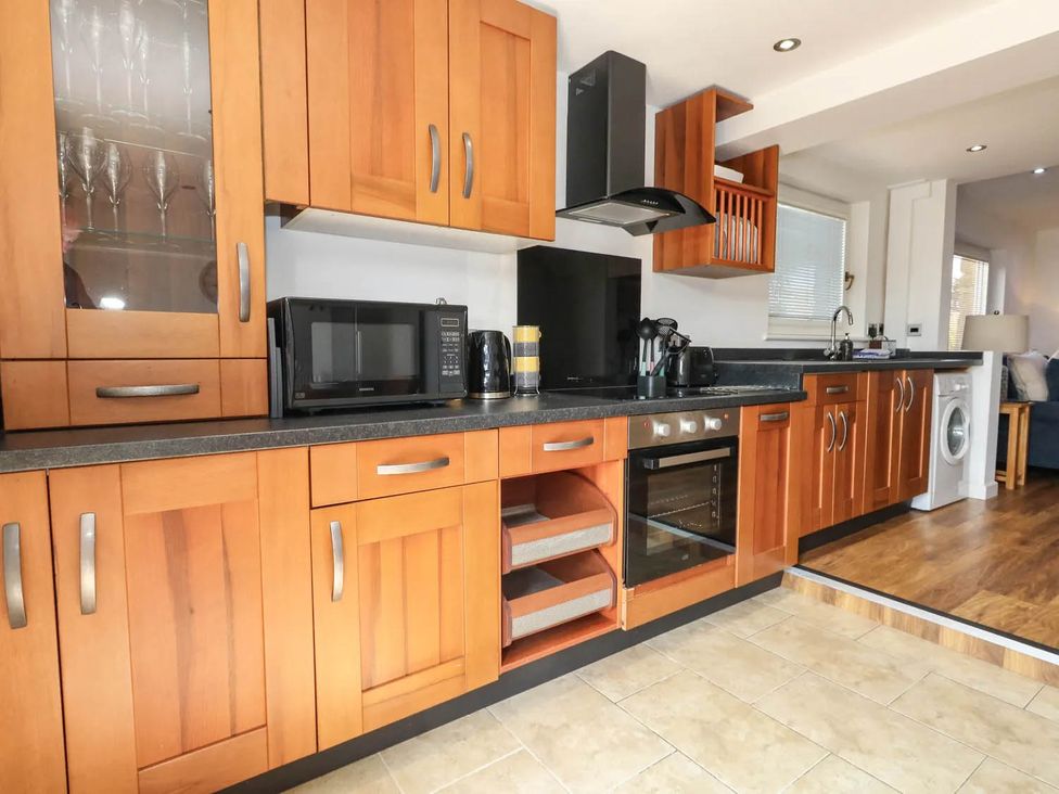 A kitchen with cabinets appliances and sink at Tides Corner in Bowleaze