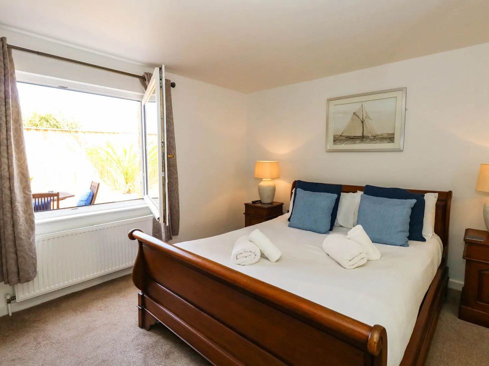 A bedroom with a bed and window at Tides Corner in Bowleaze