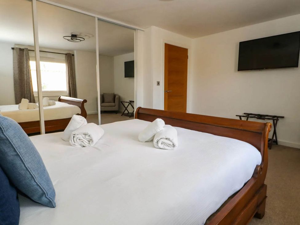 A bedroom with a bed and television at Tides Corner in Bowleaze