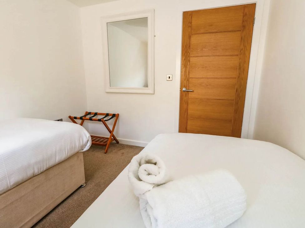 A bedroom with two beds and a mirror at Tides Corner in Bowleaze