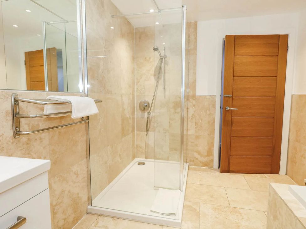 A bathroom featuring a shower and towel rack at Tides Corner Bowleaze