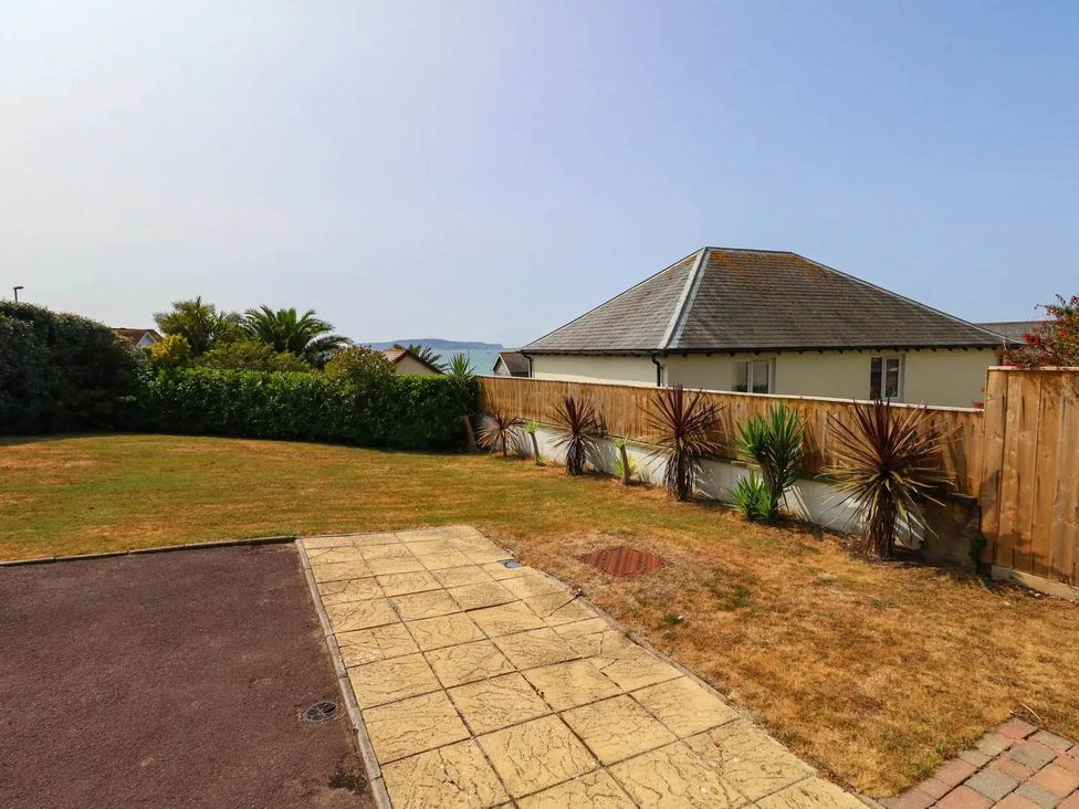 An outdoor space with grass and paved path at Tides Corner in Bowleaze