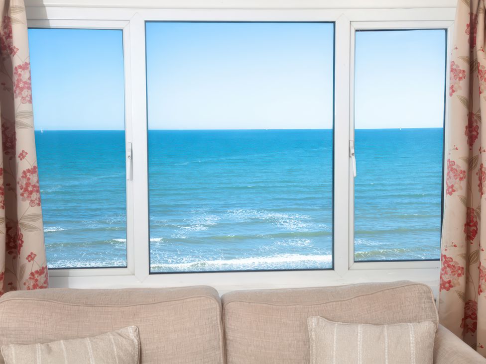 A view of the ocean from a window in a living room at Weymouth Bay Apartment C in Greenhill