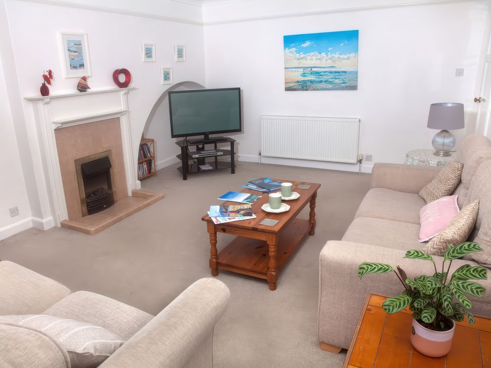 A living room with a television and a coffee table at Weymouth Bay Apartment C in Greenhill