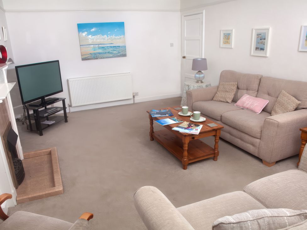 A living room with a sofa and television at Weymouth Bay Apartment C in Greenhill
