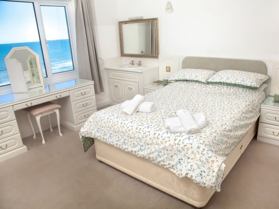 A bedroom with a bed and dressing table at Weymouth Bay Apartment C in Greenhill