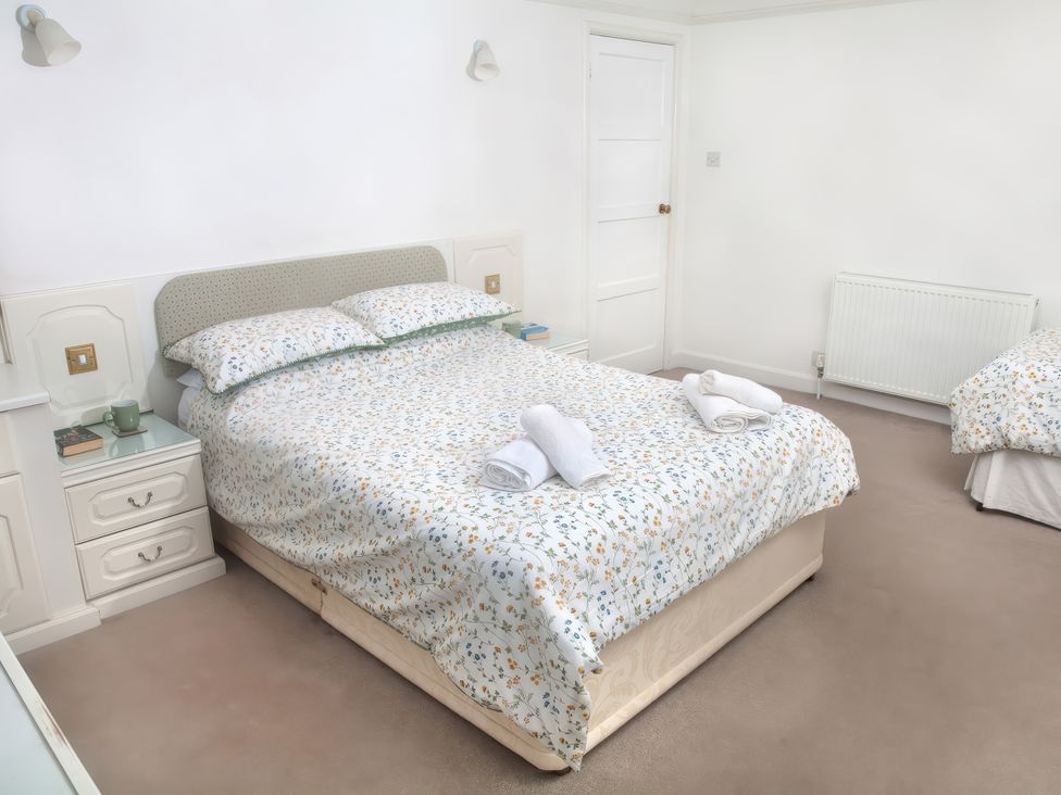 A bedroom with a double bed and a nightstand at Weymouth Bay Apartment C in Greenhill