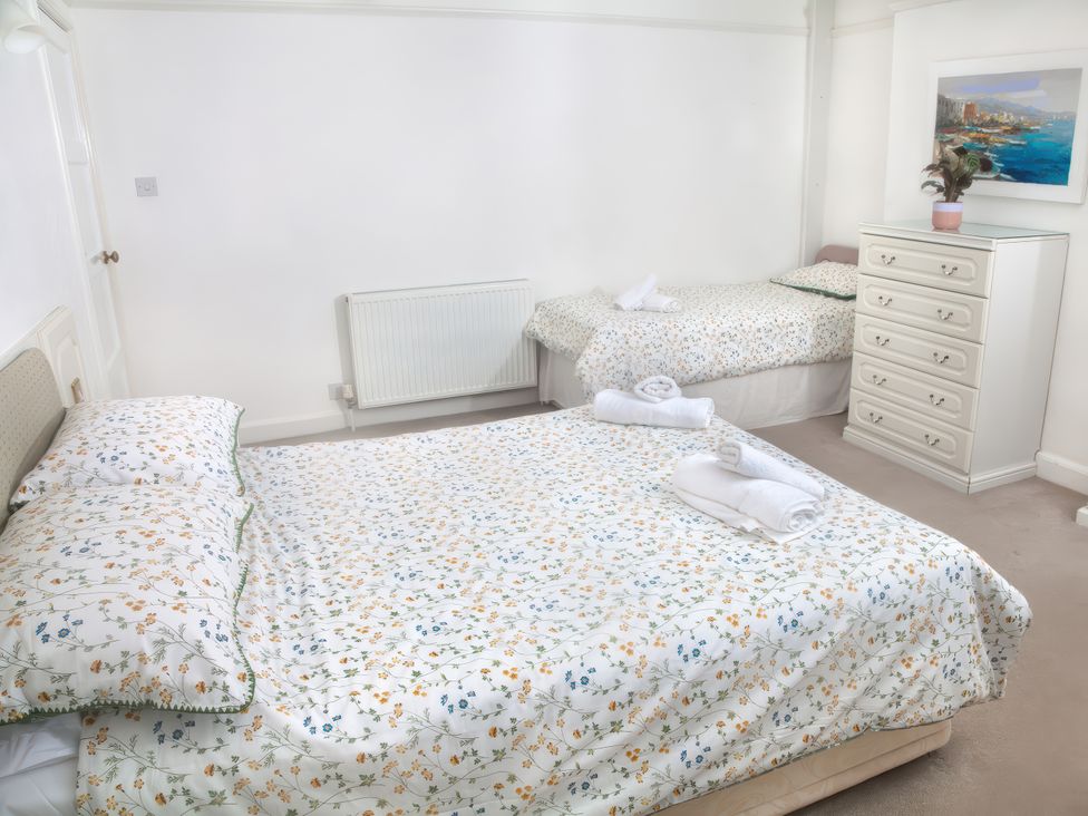 A bedroom with a double bed and twin bed at Weymouth Bay Apartment C in Greenhill