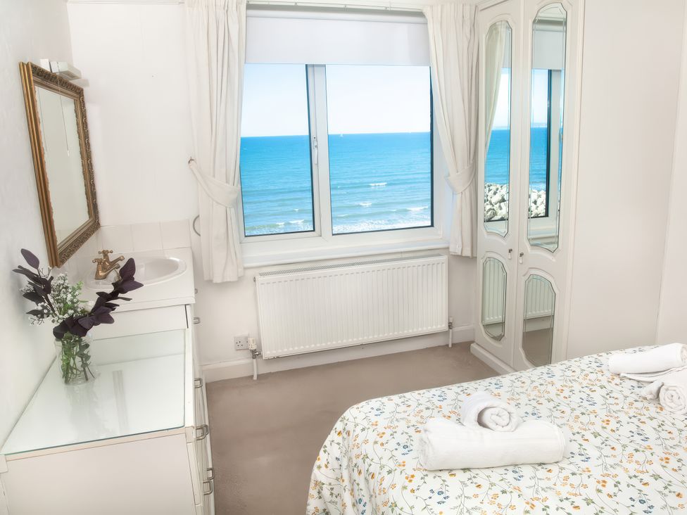 A bedroom with a view of the ocean at Weymouth Bay Apartment C in Greenhill