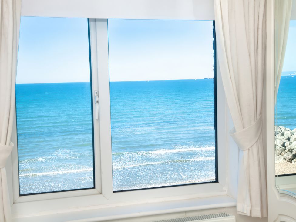 A window with a view of the sea at Weymouth Bay Apartment C in Greenhill