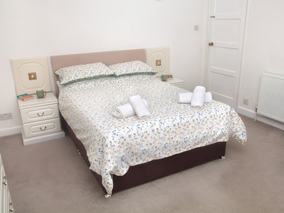 A bedroom with a bed and nightstand at Weymouth Bay Apartment C in Greenhill