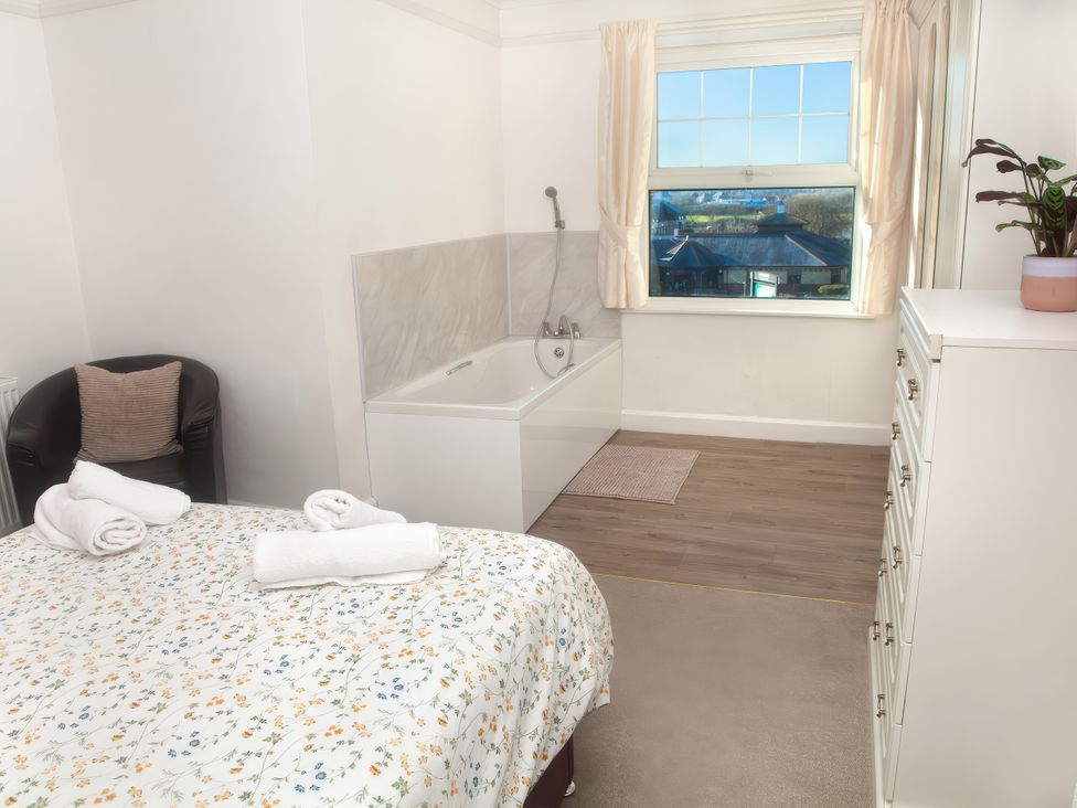 A bedroom with a bed and bathtub at Weymouth Bay Apartment C in Greenhill
