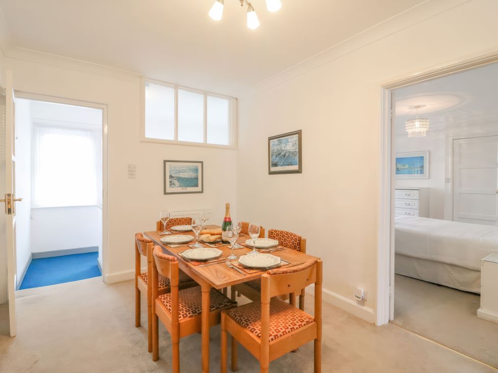 A dining room with a table set for meals at Weymouth Bay Apartment C in Greenhill