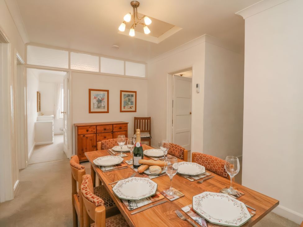 A dining room with a table set for a meal at Weymouth Bay Apartment C in Greenhill