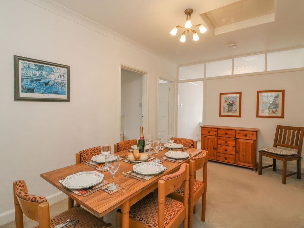 A dining room with a table set for a meal at Weymouth Bay Apartment C in Greenhill