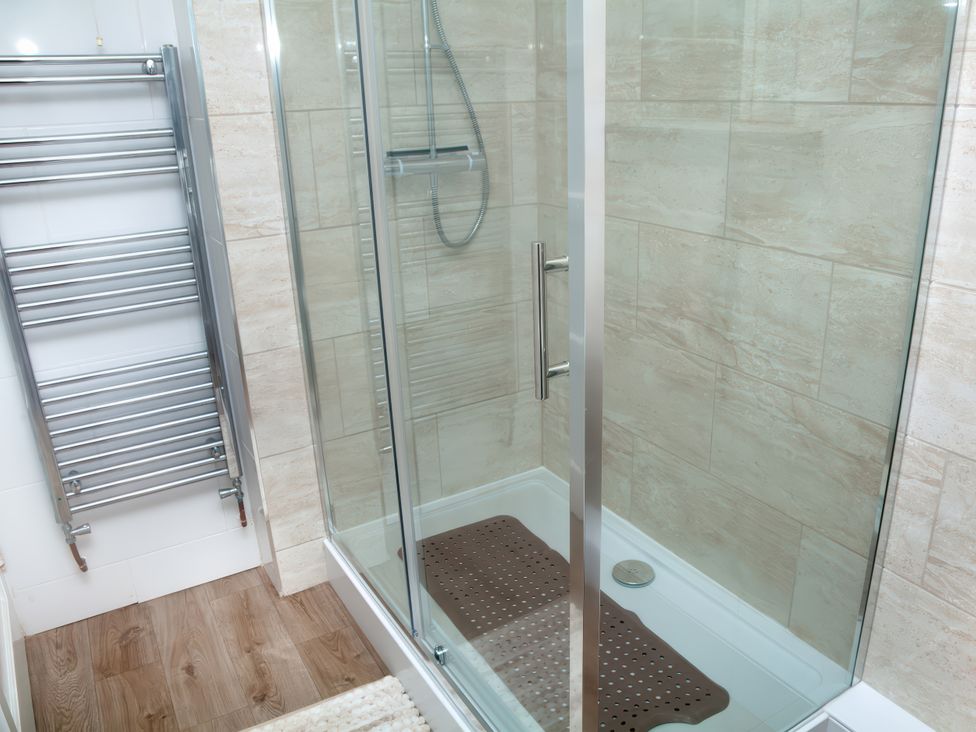 A shower enclosure with towel rail at Weymouth Bay Apartment C in Greenhill