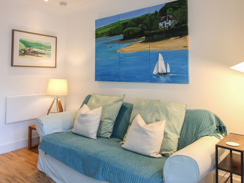 A living room with a sofa and painting at 16 Bolt Head Salcombe