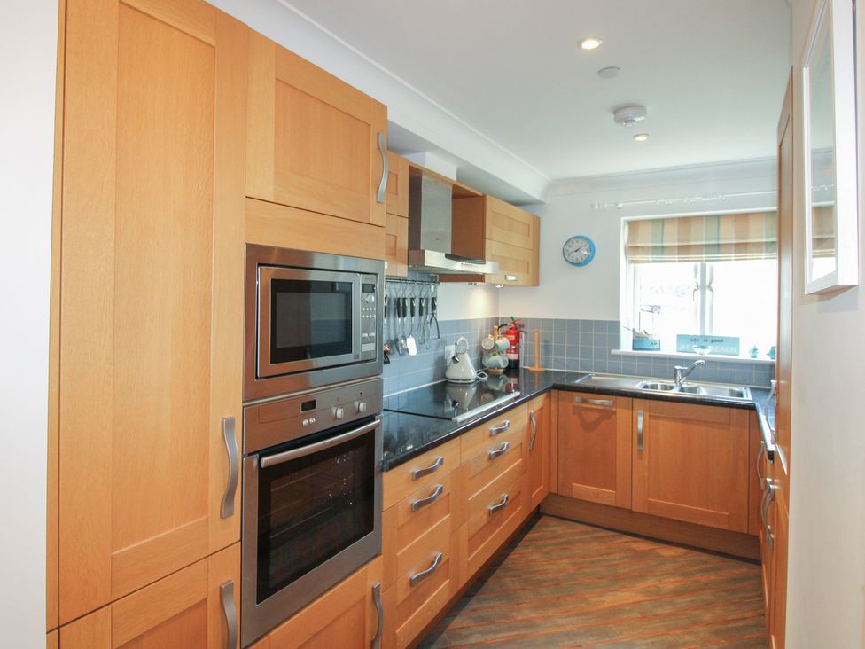 A kitchen with cabinets, microwave, oven, kettle and sink at 16 Bolt Head, Salcombe