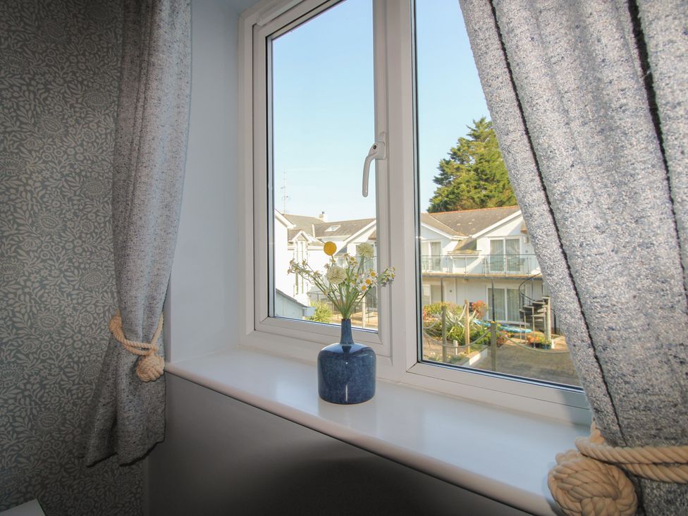 A window with curtains and a plant on the windowsill at 16 Bolt Head Salcombe