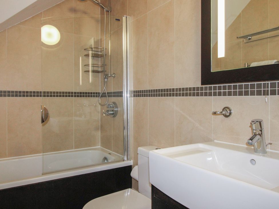 A bathroom with a shower and bathtub at 16 Bolt Head Salcombe