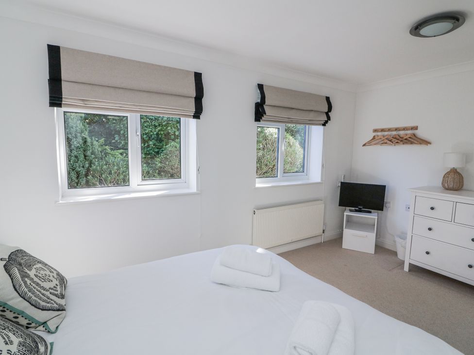 A bedroom with windows and a television at 19 Bolt Head in Salcombe