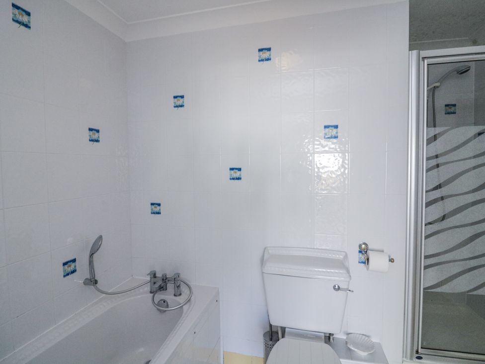 A bathroom with a bathtub, toilet, and shower at 19 Bolt Head Salcombe